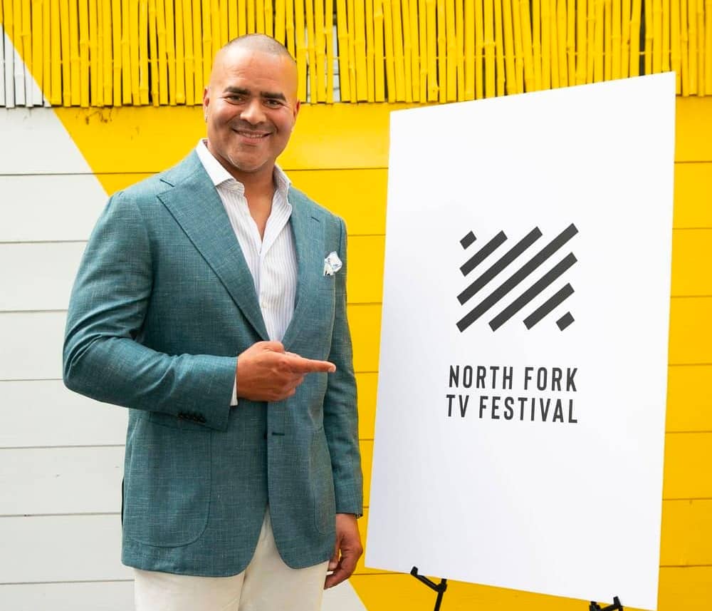 Christopher Jackson pointing to a North Fork TV Festival sign